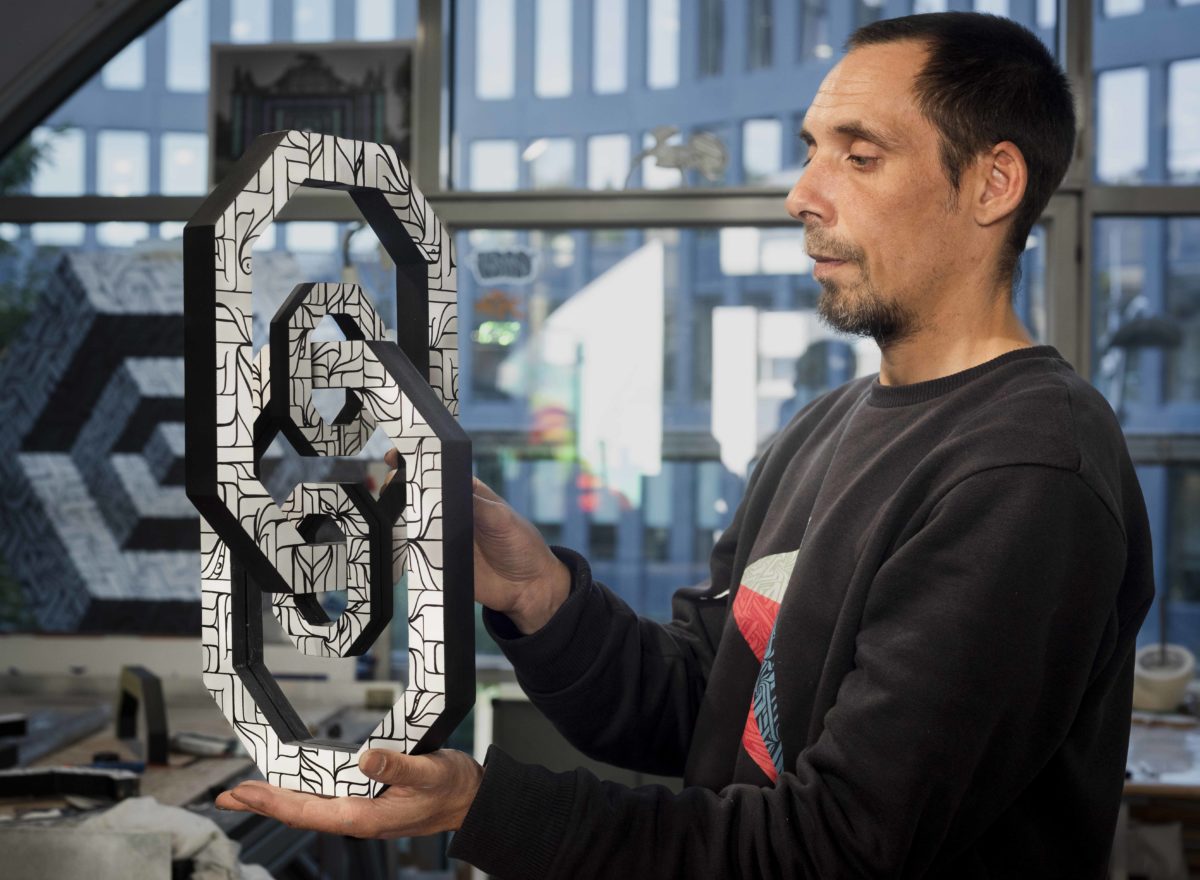 l'arstiste ASTRO dans son atelier avec une de ses sculptures